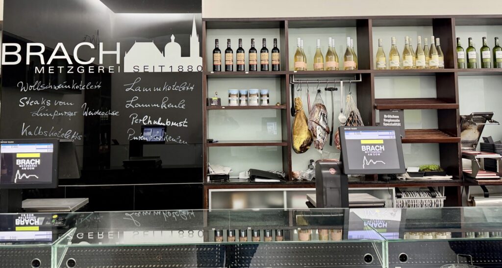 Theke der Metzgerei Brach am Dom mit Spezialitäten-Tafel, darunter Wollschwein und Limpurger Weideochse